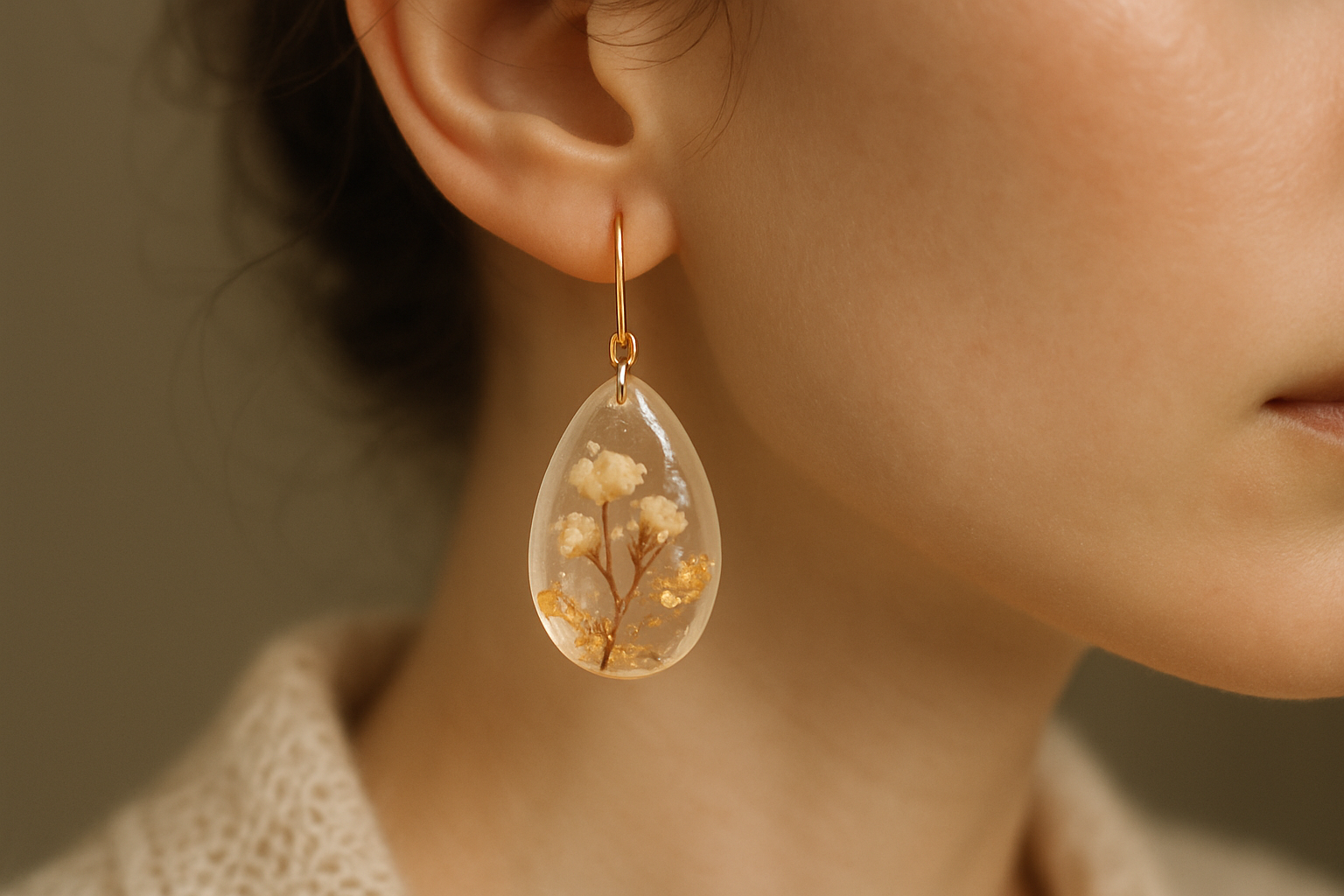 Joyeria de resina en una oreja con temática elegante y artesanal